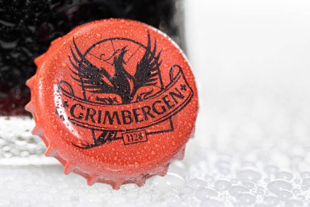 Foto de LONDRES, Reino Unido - 22 DE DICIEMBRE DE 2022: Grimbergen tapa de botella de cerveza de barril con rocío sobre blanco - Imagen libre de derechos