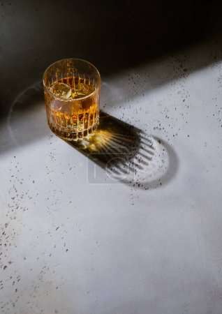 Foto de Vaso de whisky con hielo y luz dura con sombra negra.Concepto de arte - Imagen libre de derechos
