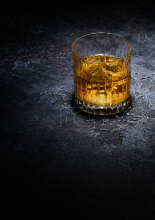 Photo for Whiskey glass with ice cubes in middle of black background.Macro - Royalty Free Image