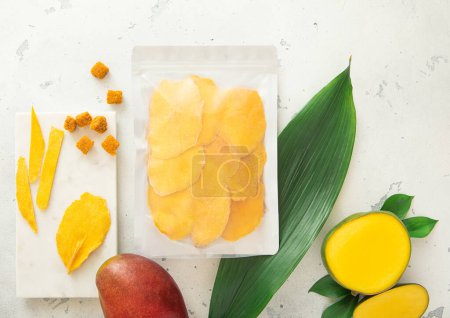 Téléchargez les photos : Lot de mangues sucrées séchées avec planche à découper en feuilles et marbre.. - en image libre de droit