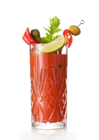 Foto de Bloody Mary cóctel de mezcla caliente con rodaja de lima y apio en blanco con aceituna y pepinillo. - Imagen libre de derechos