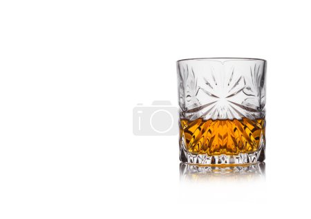Téléchargez les photos : Scotch whisky en cristal élégant verre sur fond blanc avec réflection.Espace pour le texte - en image libre de droit