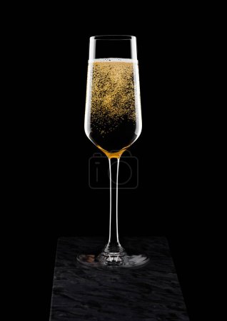 Foto de Elegante copa de champán amarillo con burbujas sobre tabla de mármol negro sobre negro
. - Imagen libre de derechos
