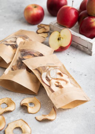 Téléchargez les photos : Paquets de frites et tranches de pommes séchées et sucrées sur fond clair. - en image libre de droit