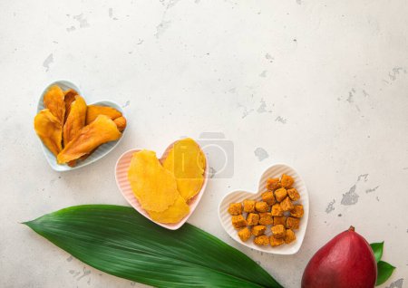 Téléchargez les photos : Tranches de mangue séchées et boules en forme de cœur sur un plateau léger.. - en image libre de droit