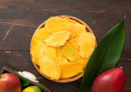 Photo for Large plate of sweet dried mangoes on wooden board.Top view. - Royalty Free Image