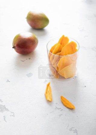 Photo for Dried mango slices with two fresh raw mangoes.Top view. - Royalty Free Image