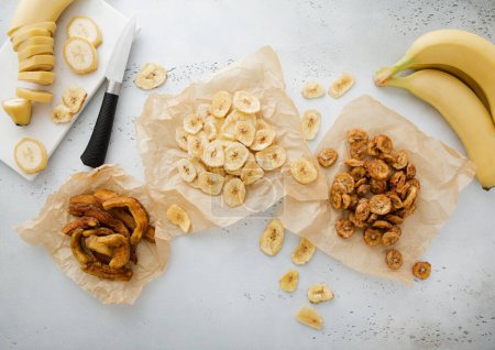 Photo for Chewy and crunchy banana slices and chips snack with raw banana and knife. - Royalty Free Image
