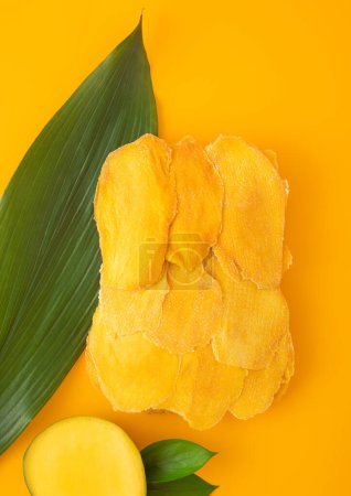 Photo for Dried large sweet mango slices on yellow background.Top view. - Royalty Free Image
