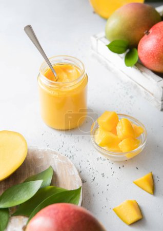 Photo for Mango puree dessert with fresh mango pieces on light background.Top view. - Royalty Free Image