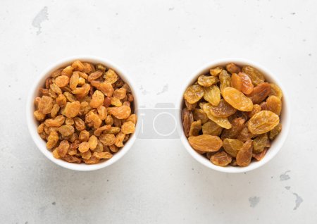 Photo for Two bowls with sweet dried green raisins on light background. - Royalty Free Image