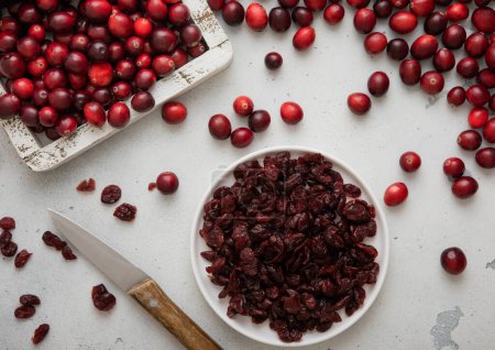 Photo for Plate with dried red sweet cranberry with ripe cranberries in wooden box. - Royalty Free Image