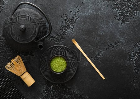 Téléchargez les photos : Poudre de thé vert matcha biologique avec fouet en bambou et cuillère et bouilloire traditionnelle japonaise en fonte sur fond noir. - en image libre de droit
