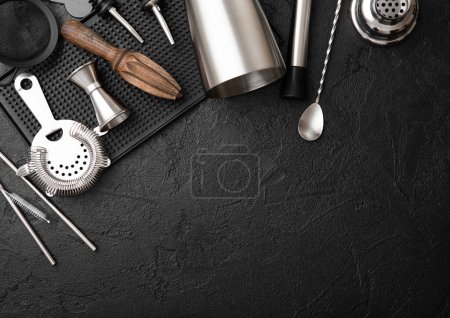 Foto de Coctelera de acero, colador, jigger y exprimidor de madera con barro en bandeja de goma con cuchara y paja plateada. - Imagen libre de derechos