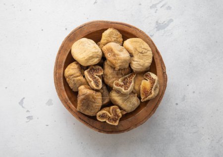Photo for Wooden bowl of dried sweet white figs on light background. - Royalty Free Image