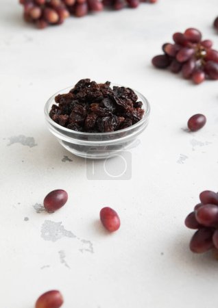 Téléchargez les photos : Raisins doux séchés foncés sur fond clair avec raisins rouges.Macro - en image libre de droit