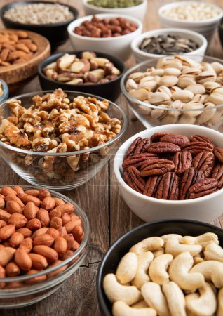 Photo for Raw walnuts and cashew with almonds and peanuts with organic nuts and seed in various assorted bowls. - Royalty Free Image