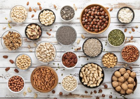 Photo for Mixed assorted raw healthy nuts and seeds in various bowls on light wooden table.Peanut,hazelnut,walnut,almonds,pistachio,sunflower,pumpkin,chia and cashew. - Royalty Free Image