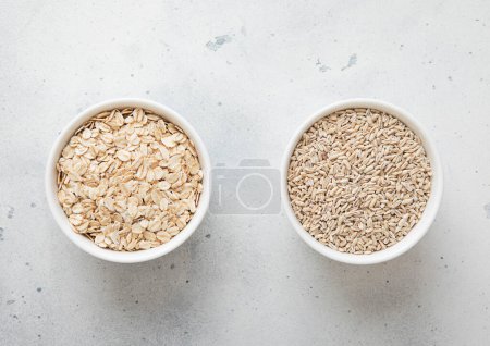Foto de Cuencos de cerámica con seco orgánico y semillas de trigo en la mesa de la cocina. - Imagen libre de derechos