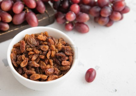 Téléchargez les photos : Raisins secs marron sur fond clair avec raisins rouges. - en image libre de droit