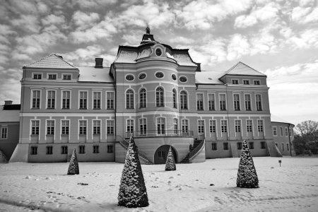garden and classicist facade of the palace in the village of Rogalin during winter, Poland,  monochrome
