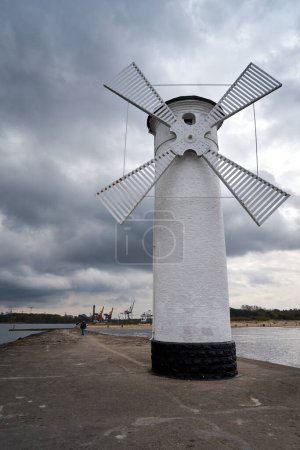 rompeolas con un cartel de navegación en forma de molino de viento en el Mar Báltico en la ciudad de Swinoujscie, Polonia
