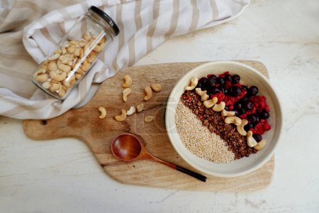 Foto de Desayuno saludable. harina de avena con bayas, granola y frutos secos - Imagen libre de derechos