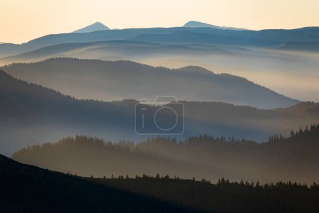 Foto de Siluetas de montaña brumosas con los primeros rayos del sol de la mañana. Foto artística de las montañas Cárpatas, Ucrania. Increíble vista de las montañas Hoverla y Petros - Imagen libre de derechos
