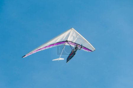 Photo for Hang glider pilot soaring in the blue sky. Extreme airborne sport - Royalty Free Image