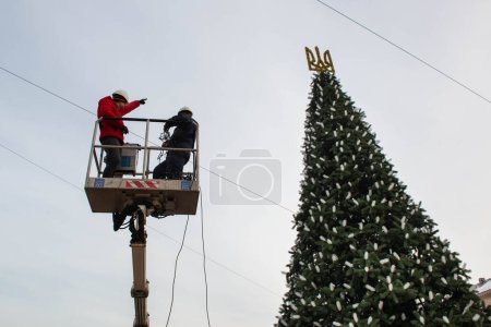 Photo for 2023-12-05 Kyiv, Ukraine. Municipal workers going up on car tower to decorate the Christmas tree - Royalty Free Image