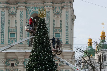 Photo for 2023-12-05 Kyiv, Ukraine. Two car towers with decorators putting christmas lights on the Christmas tree - Royalty Free Image