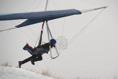 Photo for Hangglider pilot runs very fast to get airborne from the hill. Dream of flying. Modern Icarus. - Royalty Free Image