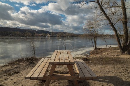 Téléchargez les photos : Lieu de repos en bois sur la rive de la rivière au début du printemps. Kiev, Ukraine - en image libre de droit