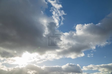 Téléchargez les photos : Fond bleu ciel avec soleil qui brille à travers les nuages - en image libre de droit