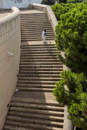 Téléchargez les photos : Femme âgée nettoyant les marches des escaliers du parc olympique de Lluis Companys, Barcelone, Catalogne, Espagne - en image libre de droit