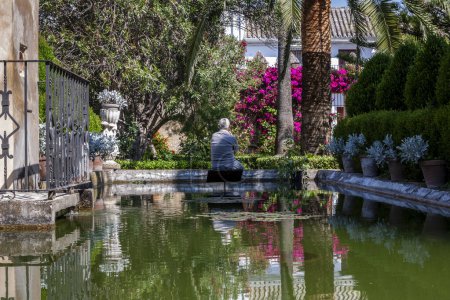 Photo for Senior sitting by the pond in a beautiful park, Bornos, , Andalusia, Spain - Royalty Free Image