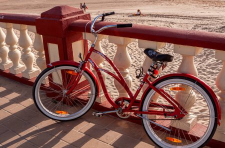 Photo for Red ladies bicycle, balustrade on the beach of Bornos, Andalusia, Spain - Royalty Free Image