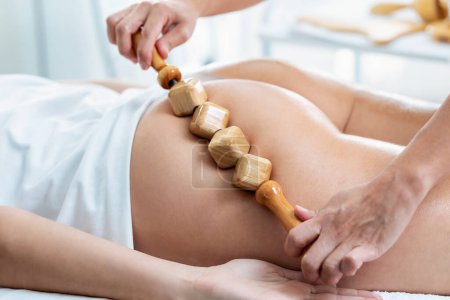 Téléchargez les photos : Shot of therapist woman doing back massage with wooden balls to a pretty woman on the spa center - en image libre de droit