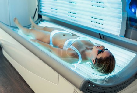 Photo for Shot of beautiful woman having tanning skin treatment in a solarium - Royalty Free Image