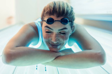 Foto de Shot of beautiful woman having tanning skin treatment in a solarium - Imagen libre de derechos