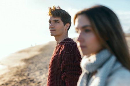 Photo for Shot of beautiful young couple in love enjoying the day in a cold winter on the beach. - Royalty Free Image