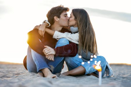 Téléchargez les photos : Portrait de beau jeune couple amoureux profitant de la journée dans un hiver froid sur la plage. - en image libre de droit