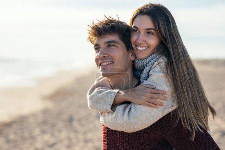 Foto de Retrato de hermosa pareja joven enamorada disfrutando del día en un frío invierno en la playa. - Imagen libre de derechos