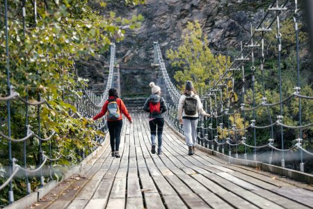 Foto de Foto de linda familia caminando en un puente en el bosque de montaña - Imagen libre de derechos