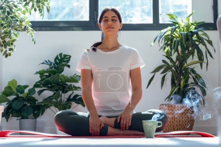 Téléchargez les photos : Prise de vue de femme sportive faisant des exercices de yoga à la maison - en image libre de droit