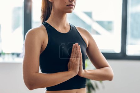 Foto de Tiro de mujer deportiva haciendo ejercicios de yoga en casa - Imagen libre de derechos