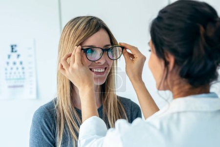 Aufnahme einer Ärztin, die sich für eine Brille entscheidet, um eine reifere schöne Patientin in ärztlicher Beratung zu testen.