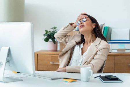 Téléchargez les photos : Prise de vue d'une femme d'affaires inquiète travaillant avec un ordinateur alors qu'elle avait des problèmes au bureau à la maison. - en image libre de droit