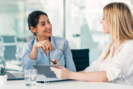 Photo for Shot of two elegant businesswomen talking while working together in a modern startup - Royalty Free Image