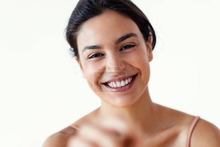 Foto de Fotografía de una hermosa mujer joven sonriendo mientras mira a la cámara en blanco aislado - Imagen libre de derechos